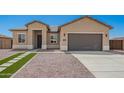 Charming one-story home featuring a two-car garage, desert landscaping, and modern architectural details at 14861 S Capistrano Rd, Arizona City, AZ 85123