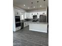 Spacious kitchen features recessed lighting, granite countertops, an island, white cabinets, and stainless steel appliances at 14861 S Capistrano Rd, Arizona City, AZ 85123