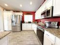 Kitchen featuring white cabinets, stainless steel appliances, granite countertops, and tile flooring at 16325 W Paradise Ln, Surprise, AZ 85388