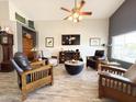 Living room featuring a ceiling fan, a TV, and assorted furniture arranged on wood-look tile flooring at 16325 W Paradise Ln, Surprise, AZ 85388