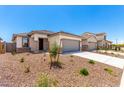 A single story home with a neutral color scheme and desert landscaping at 17043 W Fetlock Trl, Surprise, AZ 85387