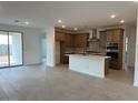 Open kitchen featuring stainless steel appliances, center island and view to the backyard at 17043 W Fetlock Trl, Surprise, AZ 85387