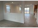 Open floor plan with tile flooring and lots of natural light from the sliding glass doors at 17043 W Fetlock Trl, Surprise, AZ 85387