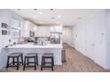 Bright kitchen with white cabinets, stainless steel appliances, and a quartz countertop island with seating at 17244 W West Wind Dr, Surprise, AZ 85387