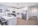 Well-lit kitchen featuring stainless steel appliances, white cabinetry, and a breakfast bar with modern stools at 17244 W West Wind Dr, Surprise, AZ 85387