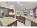 Open kitchen featuring a stainless refrigerator and large center island with sink at 19982 N Tealstone Dr, Surprise, AZ 85374