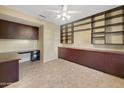 Home office with dark wood built-ins, ample cabinetry, and tile flooring at 19982 N Tealstone Dr, Surprise, AZ 85374