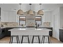 Modern kitchen features a large island with seating, pendant lighting, and contemporary cabinetry and countertops at 2546 E Roma Ave, Phoenix, AZ 85016