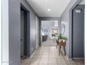 Hallway featuring tile flooring, gray walls, white doors, and a view to the living room at 25627 N 163Rd Dr, Surprise, AZ 85387