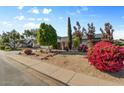 Beautiful single-story home with a nicely landscaped front yard, mature trees, and vibrant flowering bushes at 2616 E Des Moines St, Mesa, AZ 85213