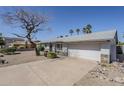 Single-story home featuring a two-car garage, xeriscaping, river rock accents, and an easy-to-maintain yard at 3138 N 82Nd Pl, Scottsdale, AZ 85251
