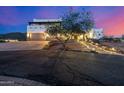 Elegant Southwestern home featuring a spacious driveway, desert landscaping, and a charming illuminated walkway at 3333 N 87Th St, Mesa, AZ 85207