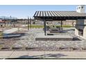 Outdoor picnic area with barbecue grills, seating, and shaded pavilion in the community park at 37091 W Parador Ln, Maricopa, AZ 85138