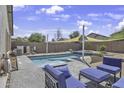 Inviting backyard pool with comfortable lounge seating and shade sail at 40845 W Thornberry Ln, Maricopa, AZ 85138