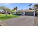 Attractive single-story home with a brick driveway, lush lawn, and meticulously maintained front yard at 4645 E Cambridge Ave, Phoenix, AZ 85008