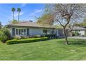 Inviting single-story home featuring a lush green lawn and well-maintained landscaping with mature trees at 4645 E Cambridge Ave, Phoenix, AZ 85008