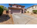 View of two-story home featuring a two car garage and desert landscaping at 4826 S 26Th Ln, Phoenix, AZ 85041