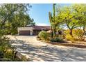 Charming single-story home featuring desert landscaping, a large driveway, and a two-car garage at 5616 E Desert Vista Trl, Cave Creek, AZ 85331