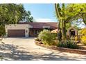 Charming single-story home featuring desert landscaping, a large driveway, and a two-car garage at 5616 E Desert Vista Trl, Cave Creek, AZ 85331