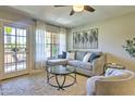Bright living room showcases a cozy gray sectional, large window with sheer curtains, and access to a private balcony at 5950 N 78Th St # 102, Scottsdale, AZ 85250