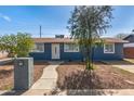Inviting single-story house with blue exterior, neat front yard, and a charming walkway leading to the entrance at 6033 S 19Th Pl, Phoenix, AZ 85042