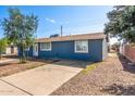 Single-story home with a blue exterior, a convenient driveway, and low-maintenance landscaping for easy upkeep at 6033 S 19Th Pl, Phoenix, AZ 85042