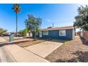 Well-maintained single-story home featuring a spacious driveway, mature landscaping, and a classic blue exterior at 6033 S 19Th Pl, Phoenix, AZ 85042