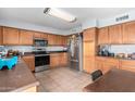 Efficient kitchen featuring stainless steel appliances, wood cabinetry and tile floors at 6528 S 258Th Dr, Buckeye, AZ 85326