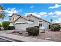 Suburban home featuring well-maintained landscaping, a neutral stucco exterior, and a tile roof at 668 S Catalina St, Gilbert, AZ 85233