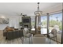 Bright dining room with modern chandelier, a stone fireplace, and backyard views at 7575 E Indian Bend Rd # 2002, Scottsdale, AZ 85250