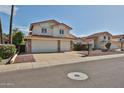Two-story home featuring a terracotta roof, attached three-car garage, and manicured landscaping at 7633 W Kristal Way, Glendale, AZ 85308
