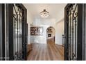Grand entrance showcases a crystal chandelier, iron doors, and archway leading to living area at 9224 N 126Th St, Scottsdale, AZ 85259