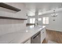 Kitchen area with white countertops and cabinets, shelving, and stainless steel dishwasher at 948 S Alma School Rd # 13, Mesa, AZ 85210