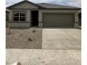 Charming single-story home featuring a two-car garage and low maintenance desert landscaping in the front yard at 2025 E Bucking Bronco Dr, San Tan Valley, AZ 85140