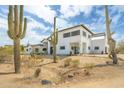 Two-story desert home with white stucco, flat roof, desert landscaping and mature cactus at 3215 N 83Rd St, Mesa, AZ 85207