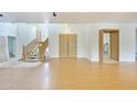 Open-concept living space featuring wood floors, a winding staircase and a double-door entryway at 3215 N 83Rd St, Mesa, AZ 85207