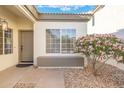 Inviting front entry featuring a window seat, stylish door, and desert-style landscaping with a blooming tree at 4446 E Chaparosa Way, Cave Creek, AZ 85331