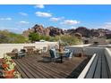 Relaxing roof deck with wood flooring, outdoor seating, and stunning mountain views on a sunny day at 5804 N Echo Canyon Ln, Phoenix, AZ 85018