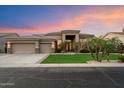 Stunning home featuring a three-car garage, desert landscaping, and a covered entryway at sunset at 1082 W Thompson Way, Chandler, AZ 85286