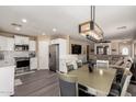 Open floor plan dining area with sight lines into kitchen and living room areas, and stainless steel appliances at 18911 N Miller Way, Maricopa, AZ 85139