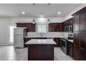 Kitchen with stainless steel appliances, island, dark cabinetry, and modern lighting at 2000 N 36Th St # 21, Phoenix, AZ 85008