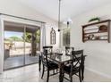 Cozy dining area with a black table set, sliding glass doors, and stylish decor at 30374 N Sunray Dr, Queen Creek, AZ 85143