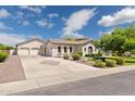 Spacious home with three-car garage and long driveway, complemented by lush landscaping at 3356 E Vallejo Ct, Gilbert, AZ 85298