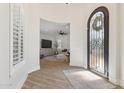 Bright foyer with wood-look tile floors, ornate iron door and view of living room at 3356 E Vallejo Ct, Gilbert, AZ 85298