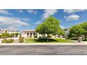 Charming single-story home featuring manicured lawn, mature tree, and covered entry at 3356 E Vallejo Ct, Gilbert, AZ 85298