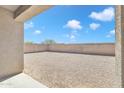 A view of the backyard with gravel and block wall fence at 43849 W Cowpath Rd, Maricopa, AZ 85138