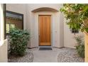 Inviting front entrance featuring a solid wood door, manicured shrubs, and a stone pathway leading to the entrance at 7445 E Eagle Crest Dr # 1015, Mesa, AZ 85207