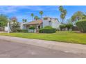 Charming home featuring a well-manicured lawn, mature palms, and a beige exterior at 8337 E Shetland Trl, Scottsdale, AZ 85258