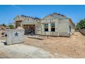 New home showcasing a frame and garage, with a large dumpster nearby at 14723 N 73Rd Dr, Peoria, AZ 85381