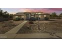 Charming single-story home boasts a well-maintained landscape, neutral tones, and inviting curb appeal at sunset at 22616 S 194Th St, Queen Creek, AZ 85142